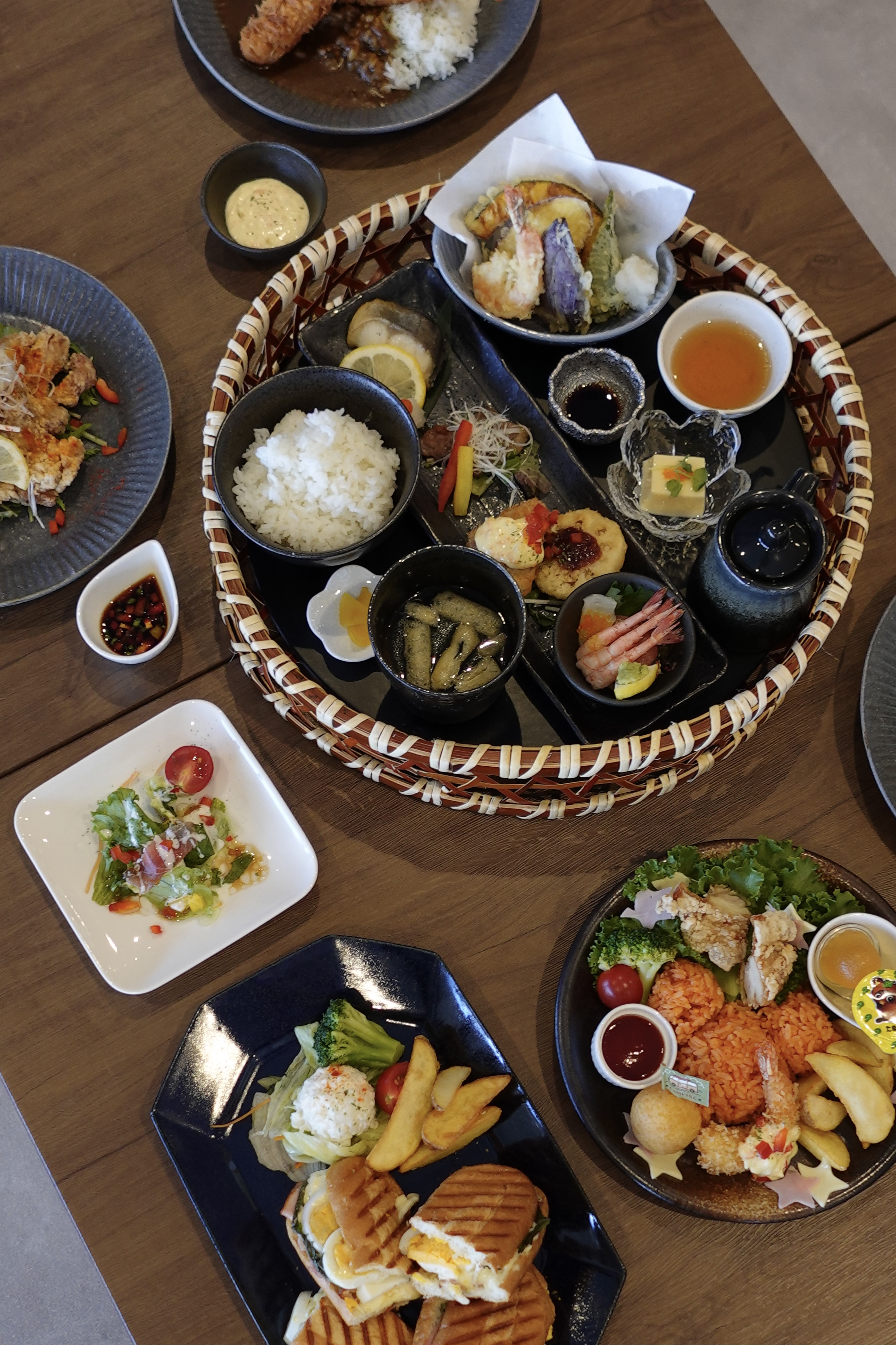 御膳やカレー、パニーニプレートが並ぶテーブル